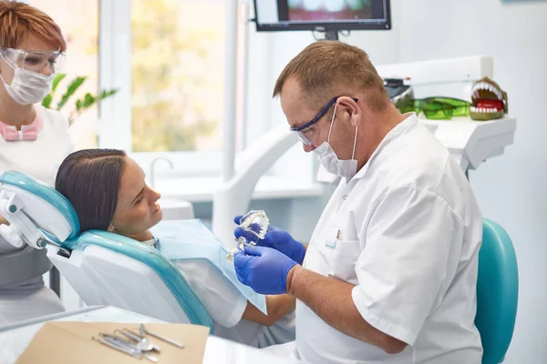 Doctor dentist treats teeth of a beautiful young girl patient. The girl on reception at the dentist. Doctor dentist treats tooth