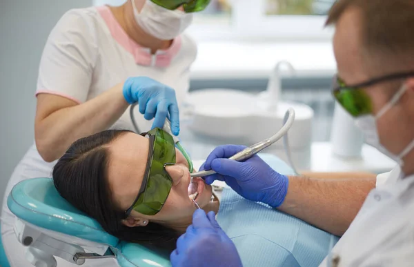 Doctor dentist treats teeth of a beautiful young girl patient. The girl on reception at the dentist. Doctor dentist treats tooth