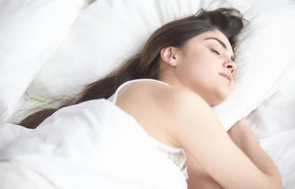 Wanita muda yang cantik berjemur di tempat tidur di pagi hari. Wajah cantik model terlihat seksi di kamera — Stok Foto