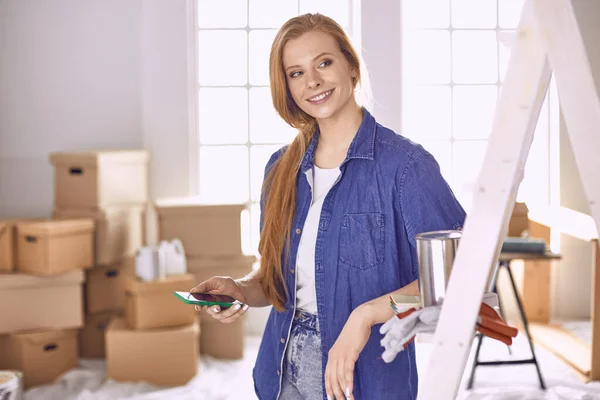 Bella giovane donna su una scala di legno bianca. Pronto a riparare la stanza. Donne concetto di lavori domestici — Foto Stock