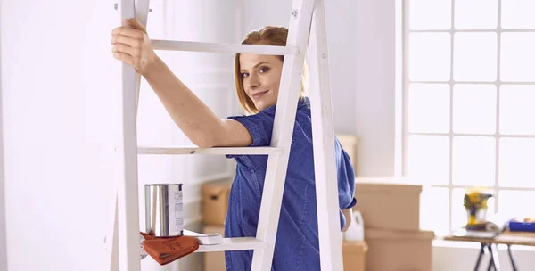 Beautiful young woman on a white wooden stepladder. Ready to repair the room. Women housework concept — Stock Photo, Image