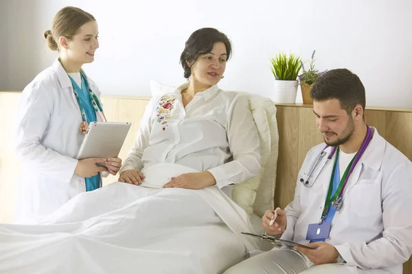 Patient mit einer Gruppe von Ärzten im Hintergrund — Stockfoto