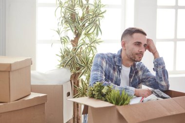 Taşındıktan sonra yeni dairede kutuları olan yakışıklı bir adam.