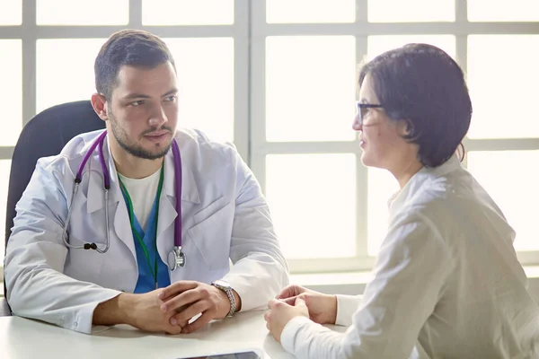 Giovane medico che parla con un paziente in ufficio — Foto Stock