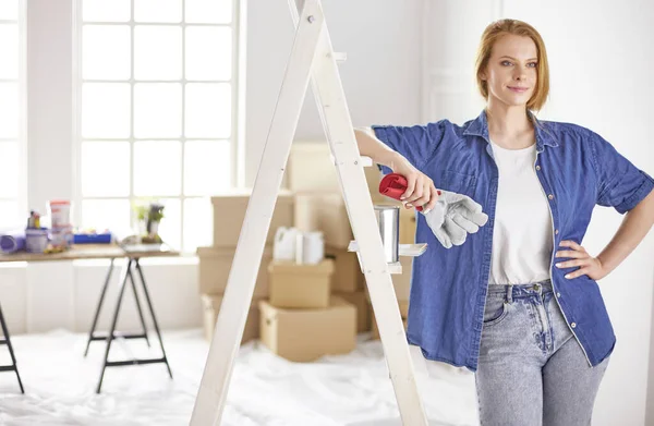 Vacker ung kvinna på en vit trappstege i trä. Redo att reparera rummet. Begreppet hushållsarbete för kvinnor — Stockfoto