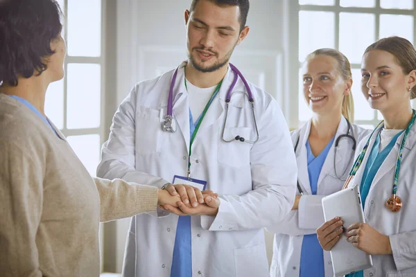 Paziente con un gruppo di medici sullo sfondo — Foto Stock