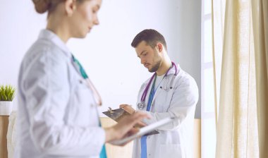 Doktor, arka planda bir grup hastada