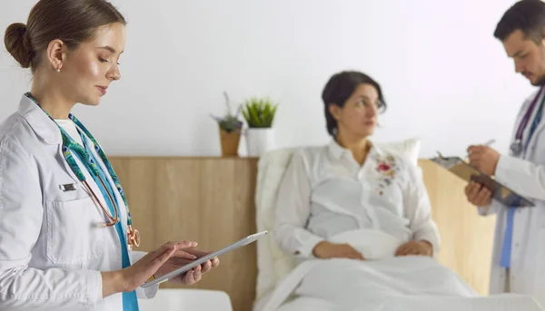 Patient mit einer Gruppe von Ärzten im Hintergrund — Stockfoto