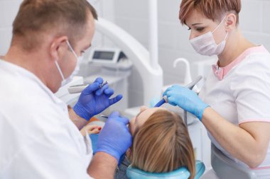 Doktor dişçi genç ve güzel bir kızın dişlerini tedavi ediyor. Dişçinin resepsiyonundaki kız. Doktor dişçi dişleri tedavi eder.