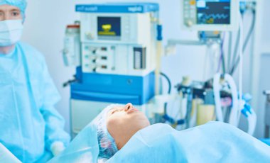 Birkaç doktor hasta operasyon masası üzerinde onların çalışma sırasında çevreleyen. Takım cerrahlar ameliyathane içinde işte