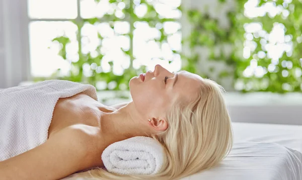 Vacker kvinna med slutna ögon får en massage i spasalong — Stockfoto