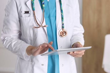 Ofiste steteskoplu kadın doktor bekliyor.
