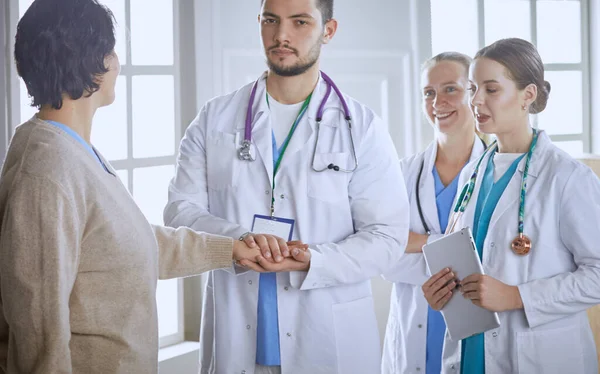 Patient avec un groupe de médecins en arrière-plan — Photo