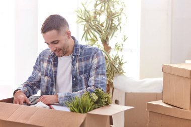 Taşındıktan sonra yeni dairede kutuları olan yakışıklı bir adam.