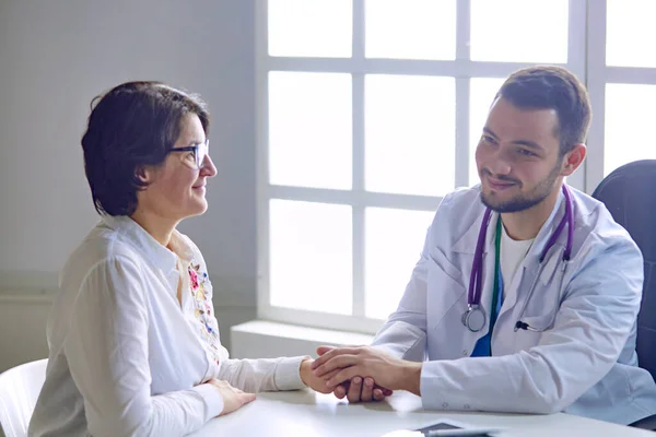 Young doctor talking to a patient in the office — ストック写真