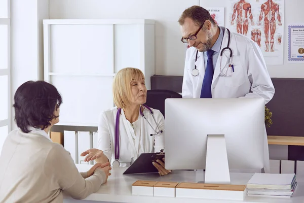 Orta yaşlı erkek doktor bir meslektaşının çalışmasına eşlik ediyor. — Stok fotoğraf