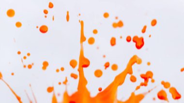 Dinamik turuncu suluboya, temiz beyaz arka planda hareket bulanıklığı. Hız, enerji ve daha küçük turuncu lekeler beyaz uzaya saçıldı.