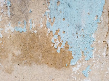 Yakın plan açık mavi boyalı duvar altında gri, pürüzlü beton olduğunu gösteren büyük, kabuk soyma bölümleri var. Eski boya dökülüyor ve çatlıyor.