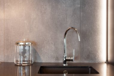 Dikdörtgen bir tasarımcı evye gri dokulu duvara su dokunun krom ile detay