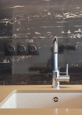 Dikdörtgen bir tasarımcı evye döşenmiş bir duvara su dokunun krom ile detay