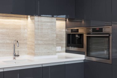 Yeni modern mutfak yapılı içinde fırın ve krom musluk suyu. LED ahşap aydınlatma