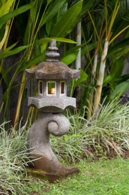 Taş fener bahçe yeşil bitkiler ile