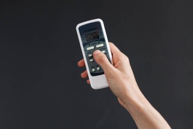 El klima koyu arka plan üzerinde harekete geçirmek için bir uzaktan kumanda ile