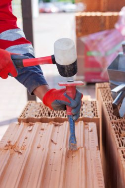 İnşaat emek tuğla kırmak için bir keski kullanın