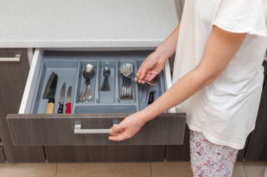 Yüksek açı üstten görünüm fotoğraf temiz beyaz ahşap masa yemek ve yeni modern ahşap mutfak çekmece farklı çatal ile açın. Kaşık yemek yemek, gıda, yapmak almak profil yan görünümü fotoğraf kırpılmış kadın