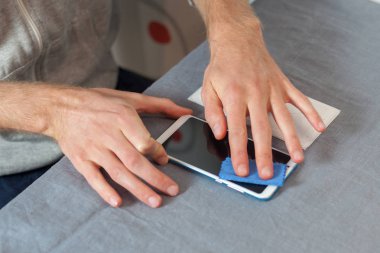 Yenileme, onarım, yedek kavramı. Yüksek açı üst kısmında profil görünümü ekran mavi mikrofiber bez peçete kırpılmış fotoğraf tamirci mendil hazırlamak plastik telefon tutkal yeni ptotect 3 boyutlu cam için