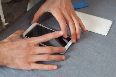 Yedek işlem kavramı. Yüksek üst kısmında profil görüş açısı onarım adam tutkal yeni koruyucu cam Smartphone cep telefonu ile evde