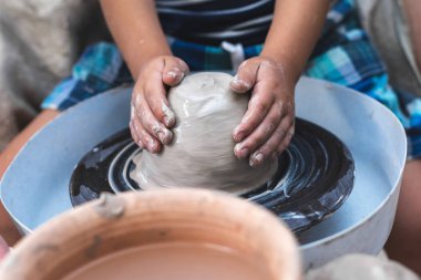 Çalışma alanı içinde küçük bir çocuk sit olun yemekleri veya kil parçası ile zanaat aracını kullanarak sofra