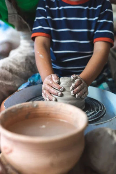 Handicraft sweet moments concept. Vertical photo of small inspired kid work on master class molding product form dirty lump of clay sit indoor workspace or studio