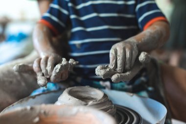 Tatlı ihale an. Güzel bayan sanatçı ve küçük esnaf öncesi çalışma alanı veya stüdyo içinde spin tekerlek şekil veya form el sanatları ürünleri için yapılan kirli eller genç çocukla birlikte boş vakit geçirmek