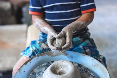 Çocukluk kavramı mutluluk zamanı. Küçük sanatçı kişi oturup kapalı çalışma alanı tutun yumru elinde sıkılmış Kil ilham