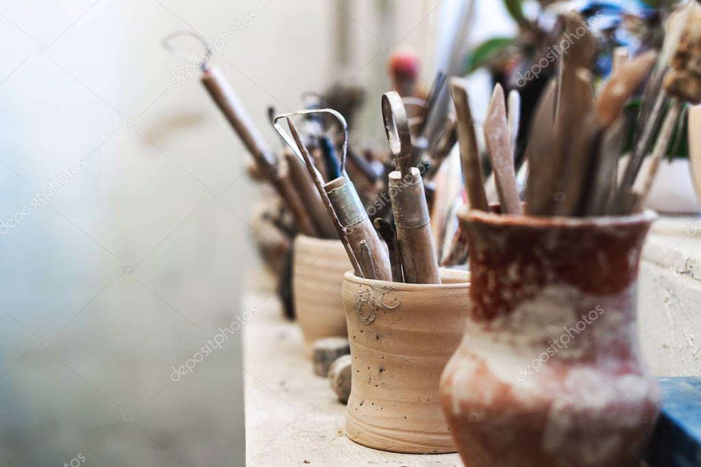 Close up photo of tools for ceramics work stand on window sill indoor workspace ready correct dishes or tableware form with copy space for text