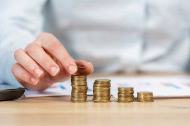 Kırpılan çalışan işveren istihdam veya girişimci kadın resmi kıyafeti tişörtünü koymuş yakından yığın oturmak grafiklerle masanın arkasında grafik grafik hafif çatı iç odak para sikke