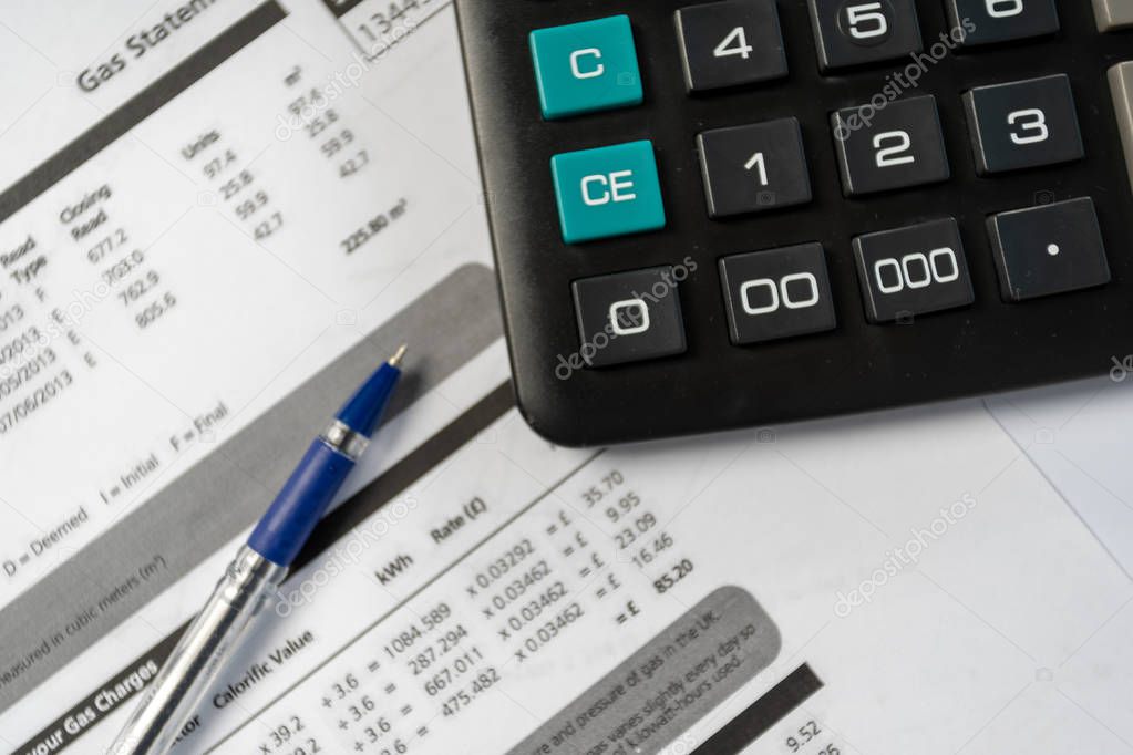 Concept of paying bills. Close up cropped photo with flat lay high angle above top view of blank calculator and pen