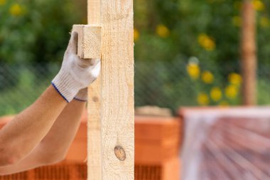 İşçi el Beyaz koruyucu eldiven holding tahta yönetim kurulu özel şirketten yüklemeden kırpılmış fotoğrafı yakından tutun İnşaat