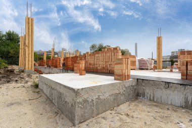 Yan görünümü yeni tuğla duvar ve ev destek unsurları. Binanın inşaat konut ahşap ve beton sütun kalıp mavi gökyüzü ile başlayan