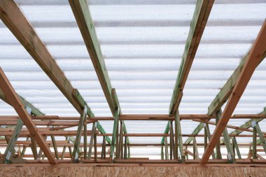 Düşük açılı güvenilir bölümleri ve beyaz windproof membran altında destekleyici kirişler ile yeni ahşap çatı üstten görünüm