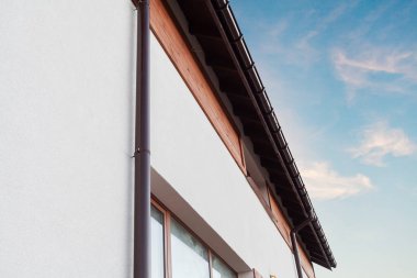 Kahverengi yağmur oluk boru yeni konfor ev kilise ile ahşap cephe ve cam pencere öğesi altında beyaz duvar fotoğrafı