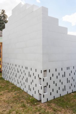 Avlu üzerinde mavi gökyüzü inşaat eleman katılımı ile bitmemiş Strafor duvar dikey fotoğraf