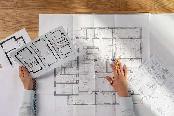 High angle above top view cropped lady in her formalwear shirt she analyzing expertise inspect read prepare technical property sit at the desk in light loft interior hold lank in hand