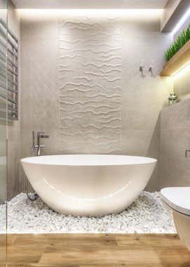 Elegance parlak banyo iç beyaz küvet, taşlar ve raflarda yeşil bitkiler ile dikey fotoğraf