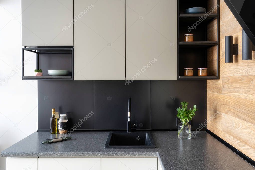 Elegance interior concept. Photo of black and white modern kitchen furniture with shelf and different stuff on table