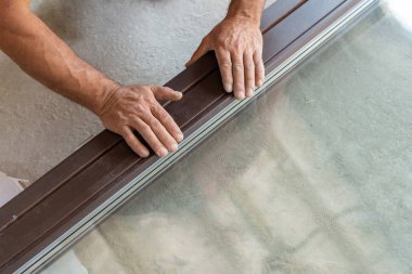 Üstten görünüm yukarıda yüksek açı kırpılmış ve yetişkin tamirci pencere çerçevesi ellerinde iki tahta öğeleri birlikte basın tutan fotoğrafını ekrana kapatın