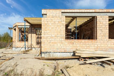 Kalıp inşaat kavramı. Kırmızı tuğla duvar, boş windows ve çatı altında destek borular ile bitmemiş ev