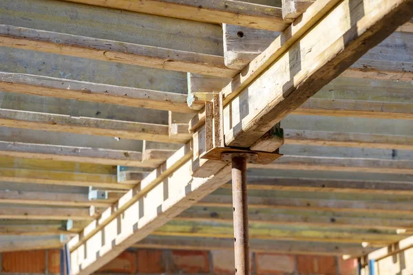 型枠建設コンセプト 未完成の建物内部サポート パイプに木の梁の低角トップ ビュー写真 — ストック写真