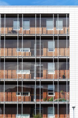 Balkonda şeffaf ve berrak cam pencere yansıması ile yüksek katlı çok katlı binanın dikey fotoğraf